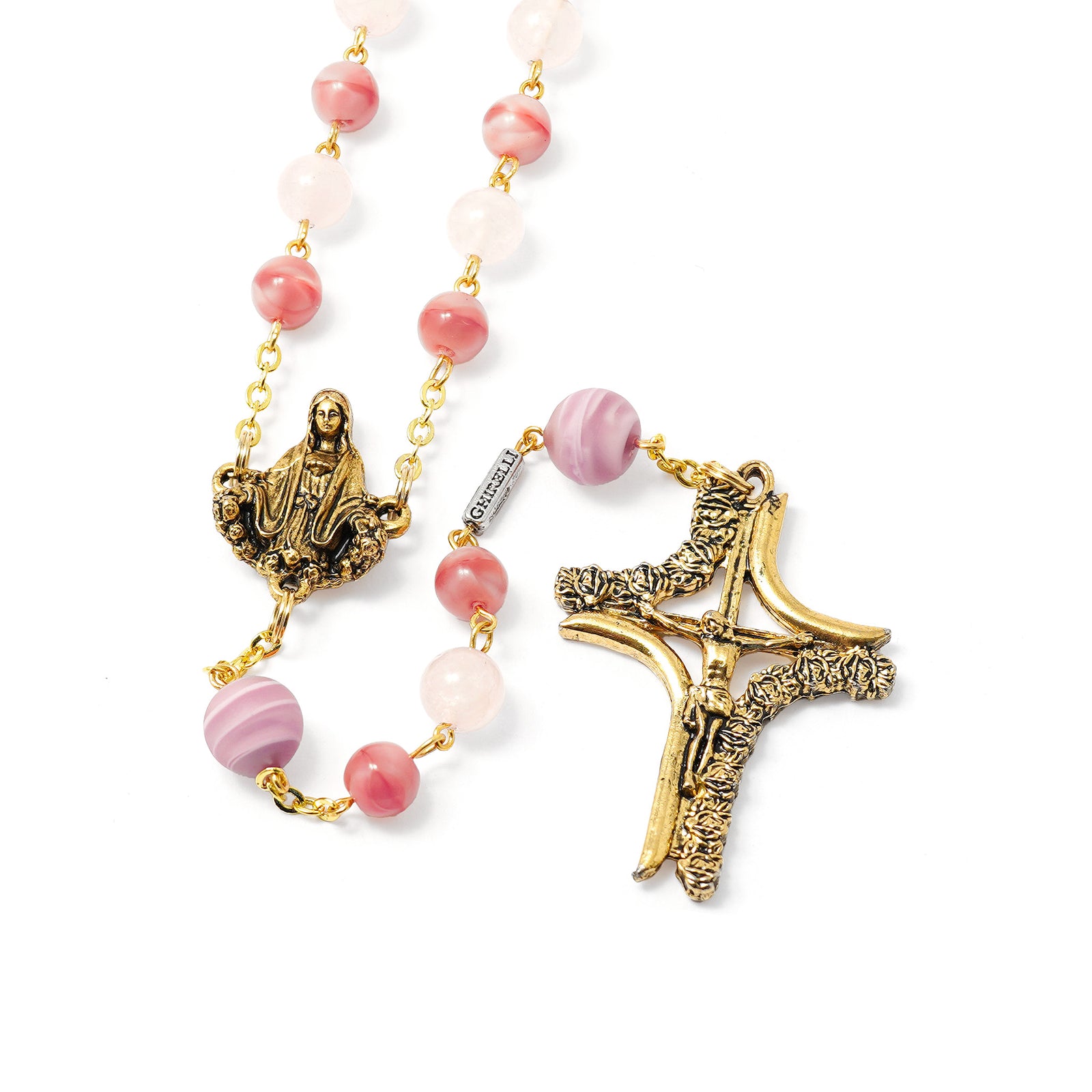 Rosary with pink beads and gold and bronze religious symbols on a white background
