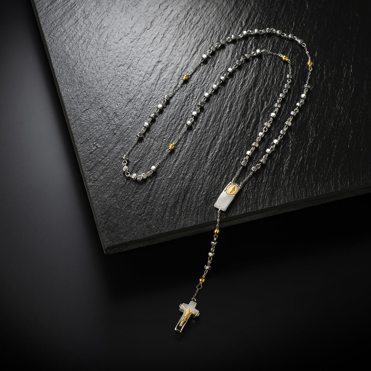 Close-up of Rosalet® Crucifix with patented closure system in Sterling Silver, Rhodium and Gold finish, symbol of faith and craftsmanship
