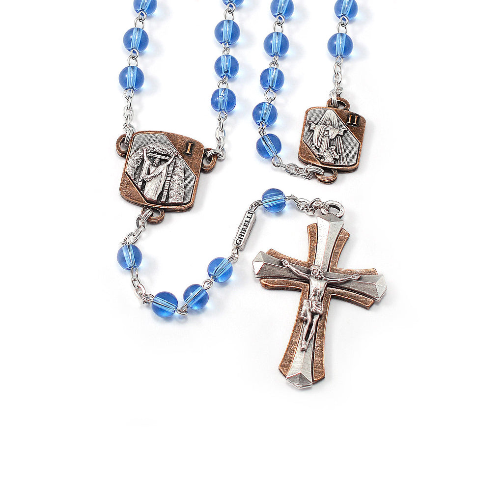 A Glorious Mysteries Rosary with blue round Bohemian glass beads, two-tone (antique silver and antique copper) Crucifix and medals, and a lock-linking chain.