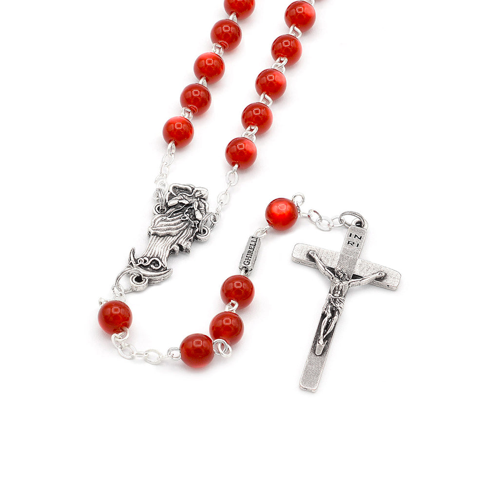 A rosary with translucent red beads and a custom centerpiece depicting Our Lady, Undoer of Knots, with a traditional Crucifix.