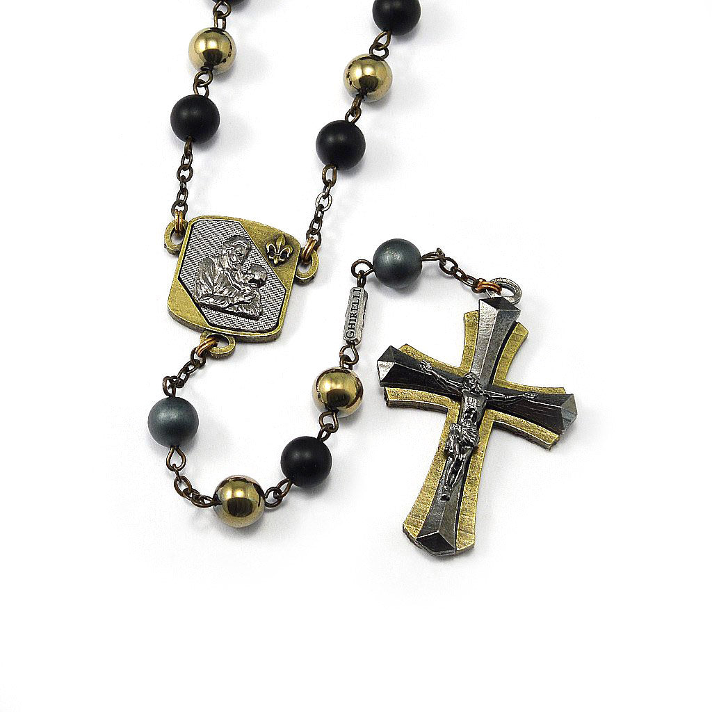 A Saint Joseph Rosary featuring bronze-colored metal components, black and gray hematite beads, and a grey agate Our Father bead, with a crucifix and a centerpiece inspired by Saint Joseph.